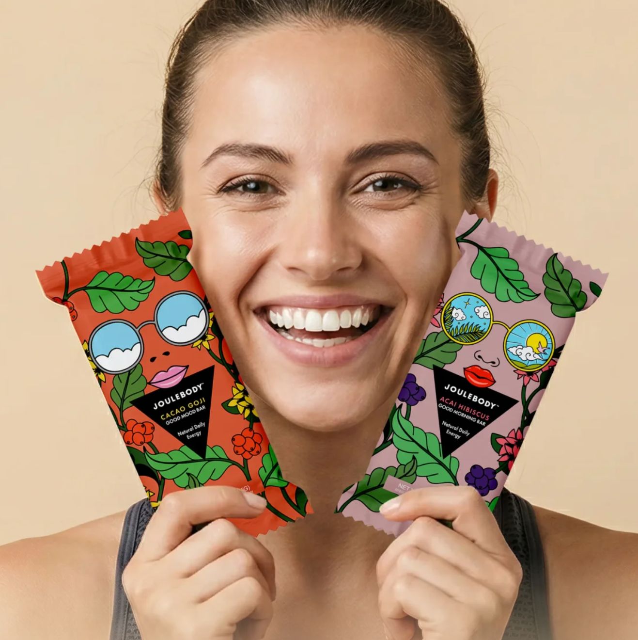 Woman smiling while holding Joulebody Good Mood and Good Morning bars