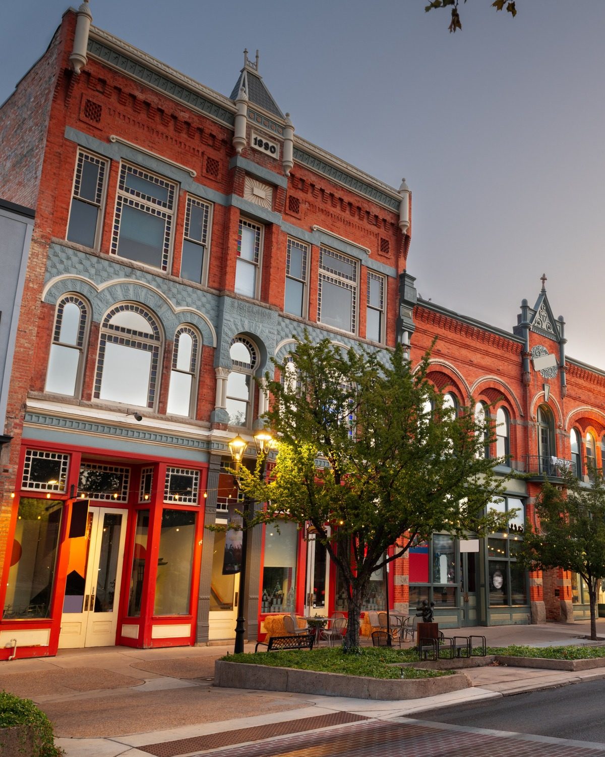 Historic main street storefront with warm interior lighting at golden hour